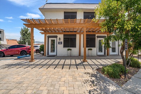 the front of a white house with a wooden porch and a driveway